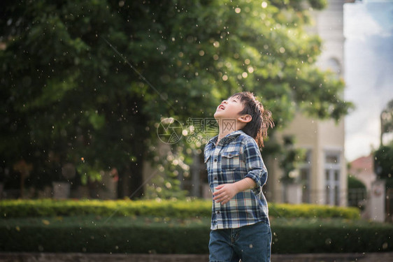 可爱的亚洲孩子在雨下图片