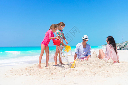 洛阳铲家庭在热带白色海滩背景