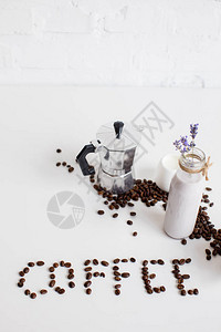 法国新闻牛奶罐和用零散咖啡豆和白桌上单字图片