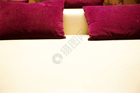 白色真皮沙发上的Claret枕头照片图片