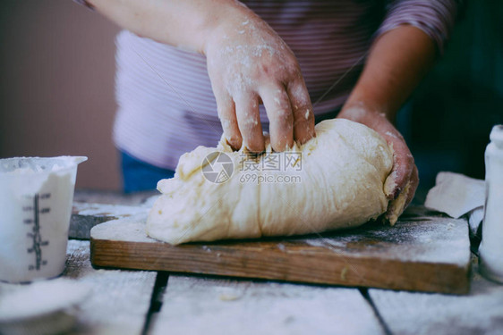 关闭了面包师揉面团的视图自制面包手在木桌上准备面包团准备传统的自制面包女人手揉新图片