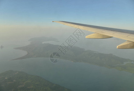 一架飞机的翼在海景和日出上空飞行图片