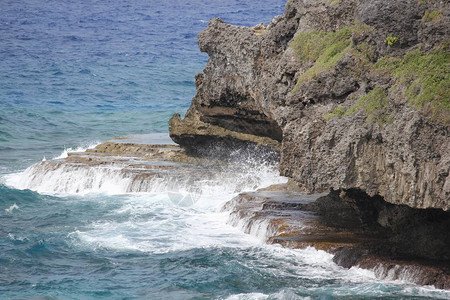 海浪拍打着岩石平台和海洋中的陡峭悬崖图片