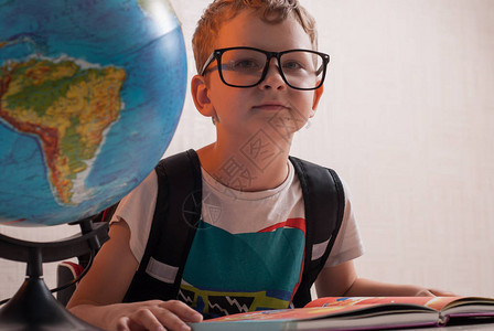 在班上书桌的年轻男孩快乐地理课图片
