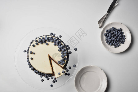 上面的切片芝士蛋糕视图玻璃柜上有蓝莓图片