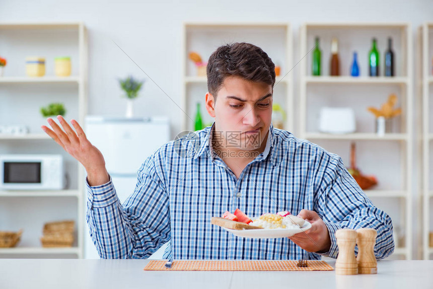 年轻丈夫午餐时在家吃无味食图片