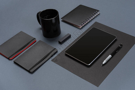 灰色桌面上的空白黑色纸片黑色文具和咖啡杯的平铺小样创意工图片