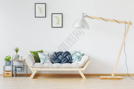 现代简约阁楼配有巨大的木灯带绿色和蓝色枕头的木沙发植物和自背景图片