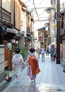 一位艺妓和Maiko在下午走过Miyagawacho街区的街道图片