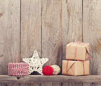 圣诞礼物盒和木墙前的装饰用背景图片