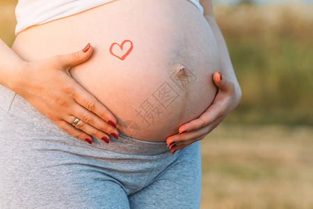 怀孕9个月的孕妇怀着签名爱的肚子图片