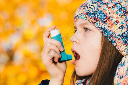 在公园使用哮喘吸入器的年轻女孩图片