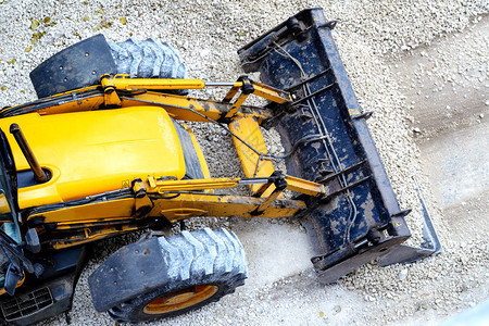 黄色推土机装载砾石用于修路图片