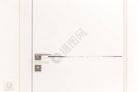 白色现代门上的金属门把手图片
