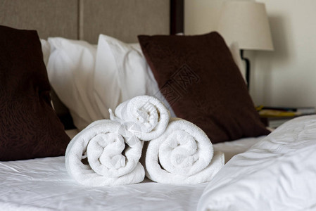 酒店房间床上的卷毛巾图片