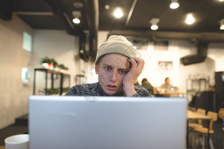 受孕的年轻人在舒适的咖啡馆里看着笔记本电脑的显示器喝杯咖啡自由职业者图片