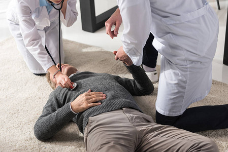 医生用听诊器检查中年男子沉睡无意识的中年人昏迷状图片