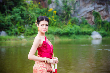 身着泰国传统礼服的美丽的亚洲妇女在河图片