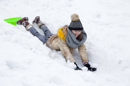 可爱的小女孩玩雪他滑到山图片