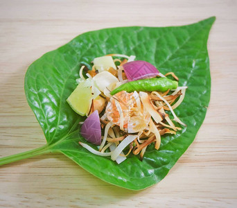 泰国传统小吃和甜点MiangKum菜或甜辣槟榔叶卷图片
