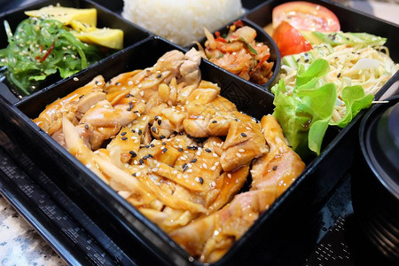 传统日本料理便当盒或多层盒配照烧鸡肉饭沙拉玉子烧或煎蛋卷日式裙带菜或海图片