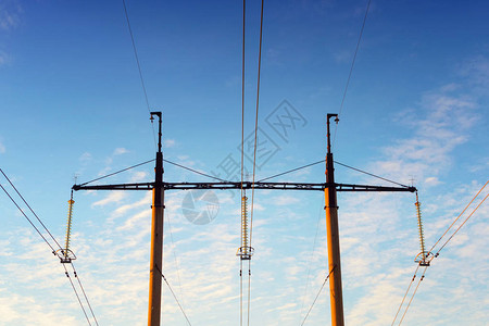 蓝天对面的高压塔和高压电线光线下的电网城图片
