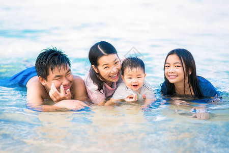 亚洲家庭在沙滩和夏天度假的图片