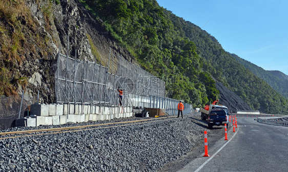 工人在今天公路一号开通之前急于完成路边岩图片