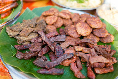 新准备的熏猪肉和香蕉叶上的牛肉烧烤选择图片