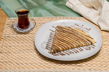白盘上配有土耳茶的巧克力酱俄罗斯布利图片