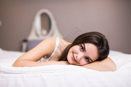 一个女人躺在被子下面的床尾图片