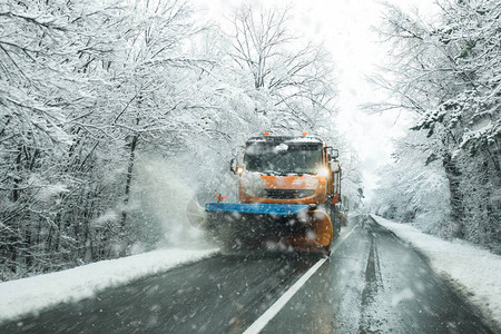 在路面撒盐以防止暴风雪冬季天气下结冰的雪犁车和灰渣车前视线图片