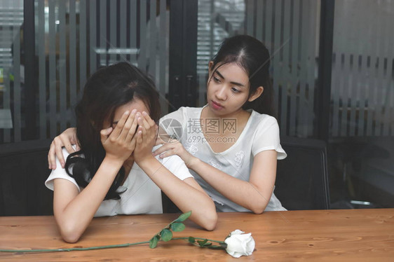 令人沮丧的典型形象是亚洲女压抑地安慰着一位悲伤的抑郁的女朋友图片