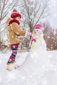 冬天的孩子在雪中做雪人图片