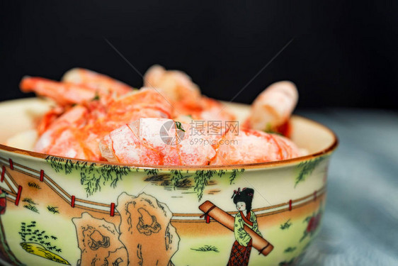 以木制背景的碗中煮熟的虾子图片