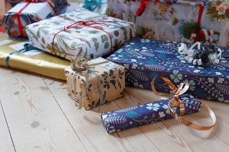 用金色丝带装饰的彩色礼品纸包裹着一堆圣诞礼物焦图片