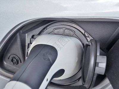 电动车或EV汽车通过EV充电插座和插头在电池中充电图片