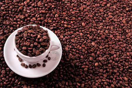 装满烤豆的白咖啡杯背景图片