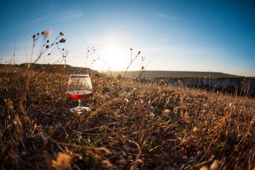 日落时分在干草上喝一杯红酒夕阳下美丽风景的图片