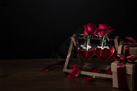 两朵红玫瑰在心脏形状的花瓶木图片