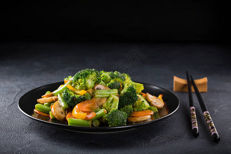 黑色盘子上的热炒蔬菜健康的亚洲食品概念图片