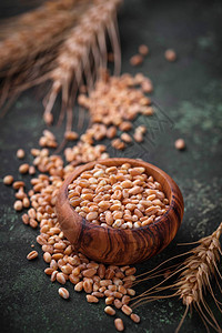 生锈的背景上的小麦籽粒和小穗选择性聚焦图片