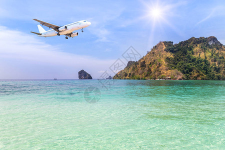 客机降落在蓝色大海的小岛和蓝天的热带海滩上图片