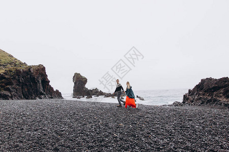 年轻夫妇在雨天沿岩石图片