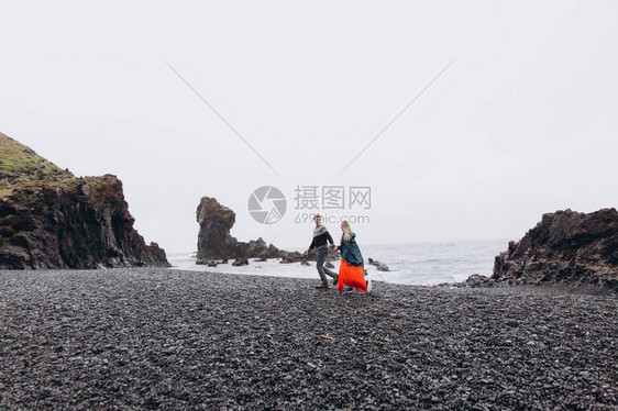 年轻夫妇在雨天沿岩石图片