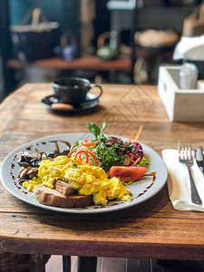 Omelet带面包和蔬菜在木制桌上图片