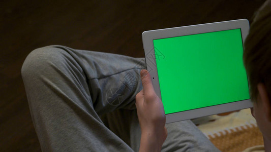 模糊的人拿着带有空白可编辑绿屏的平板电脑的后视图男子手持平板电脑与图片
