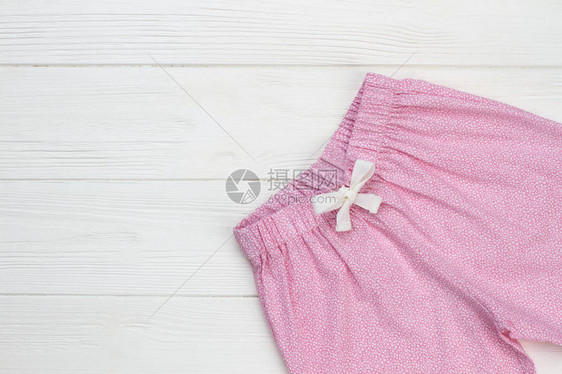 白纹粉色裤子木制背景的睡衣服装图片
