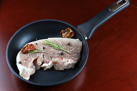 桌子上煎锅里的牛排猪肉图片