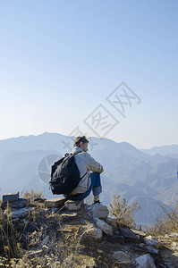 人坐落在山顶上望着山的远处图片